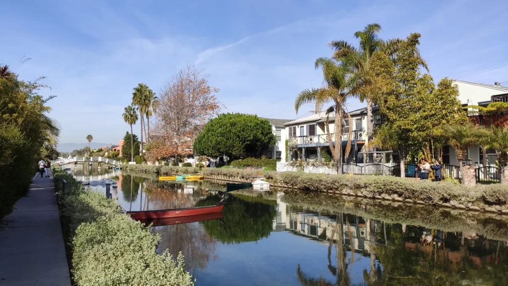 Homes, trees, water, and a footbridge along a Venice canal in Los Angeles