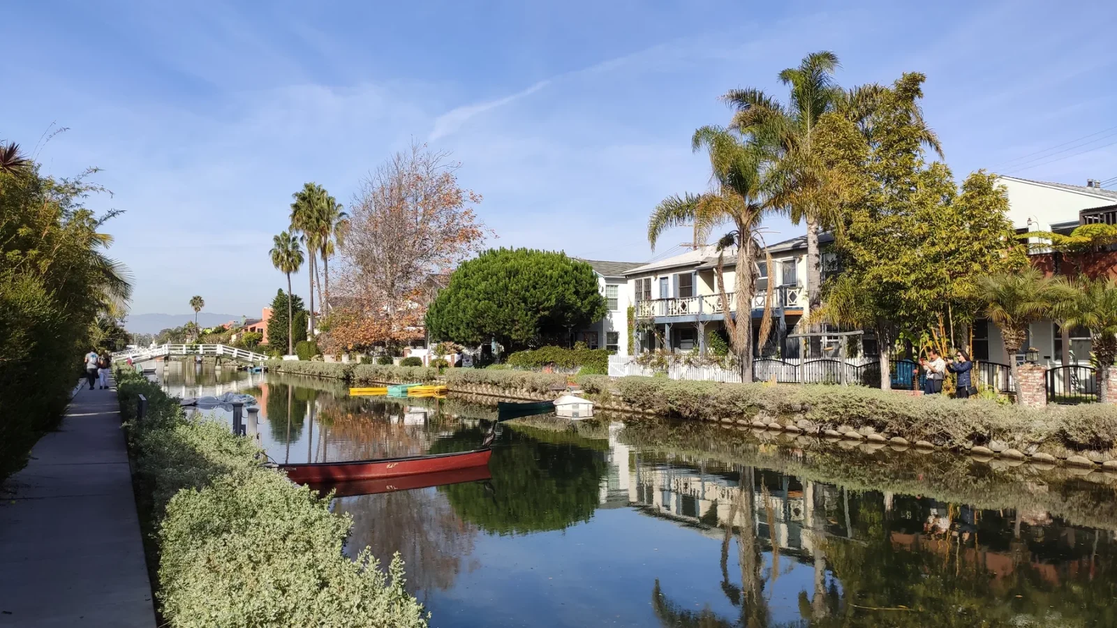 Homes, trees, water, and a footbridge along a Venice canal in Los Angeles