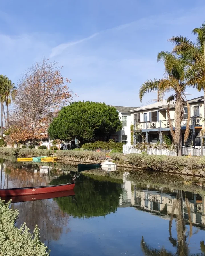 Homes, trees, water, and a footbridge along a Venice canal in Los Angeles