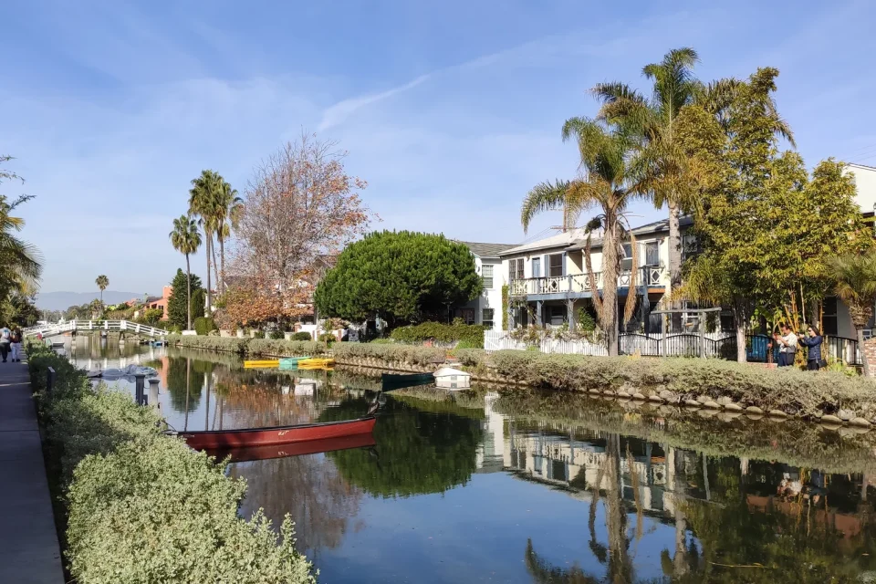 Homes, trees, water, and a footbridge along a Venice canal in Los Angeles